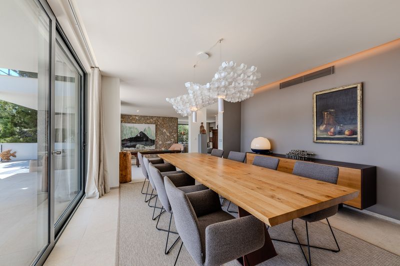 Designer dining room with a sculptural chandelier opening to the terrace