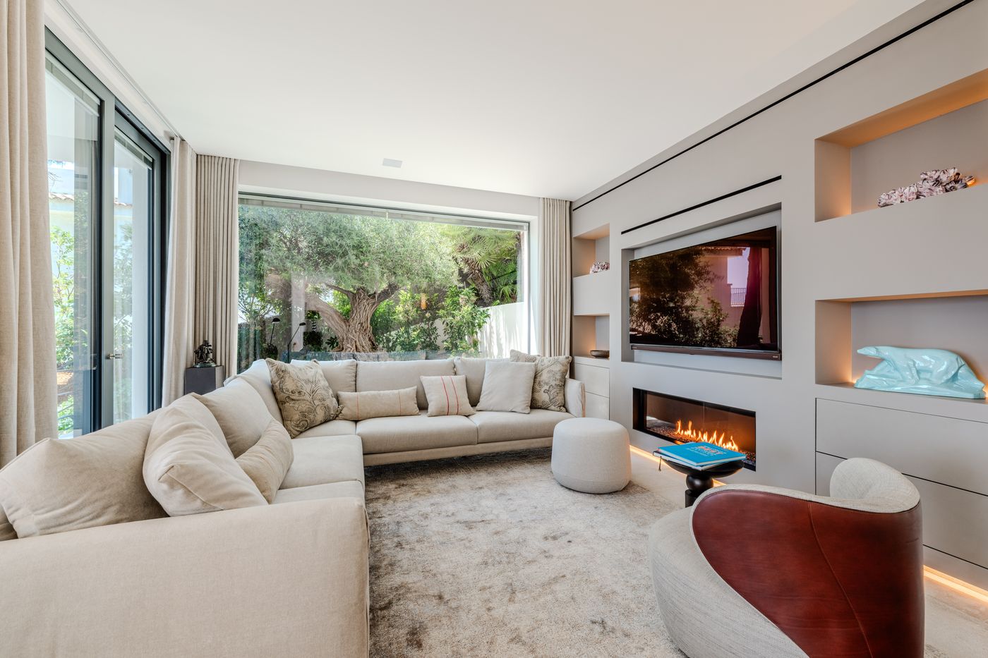 Living room with a sectional sofa, fireplace and floor-to-ceiling sea-view glazing