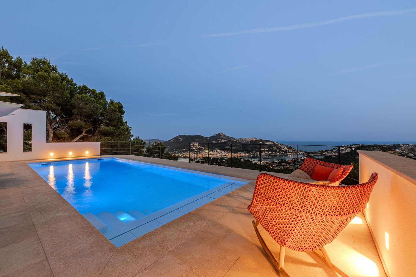 Pool terrace at dusk with the lit infinity edge