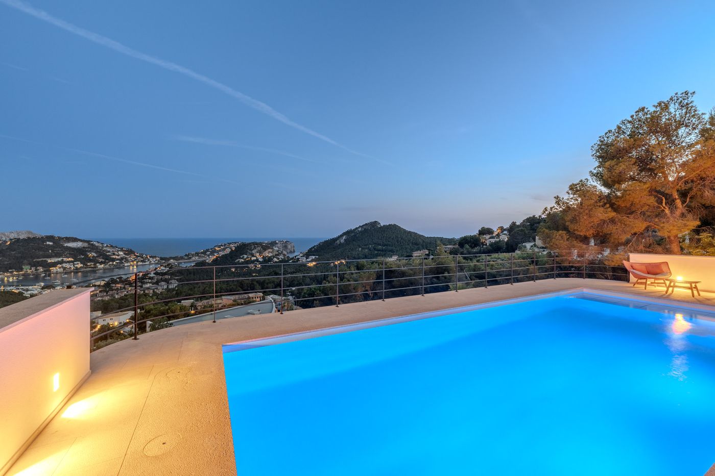 Infinity pool and sun terrace glowing at dusk
