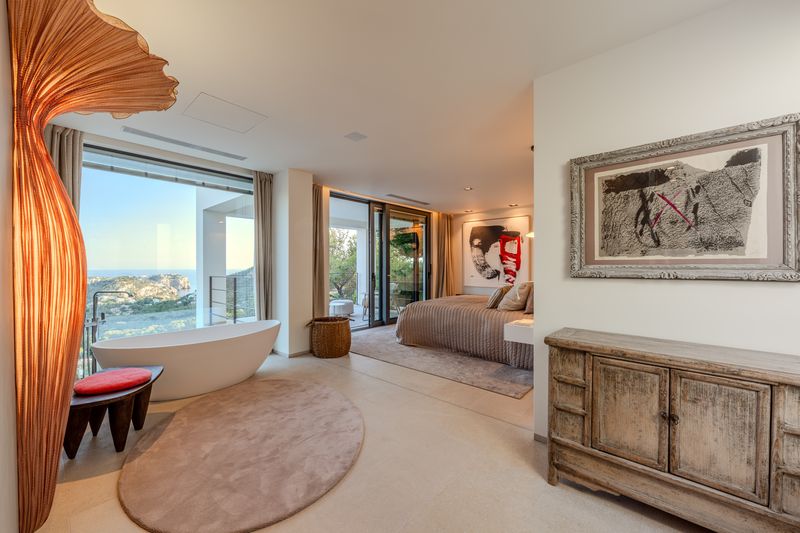 Bedroom suite with a sea view and a sculptural wall artwork