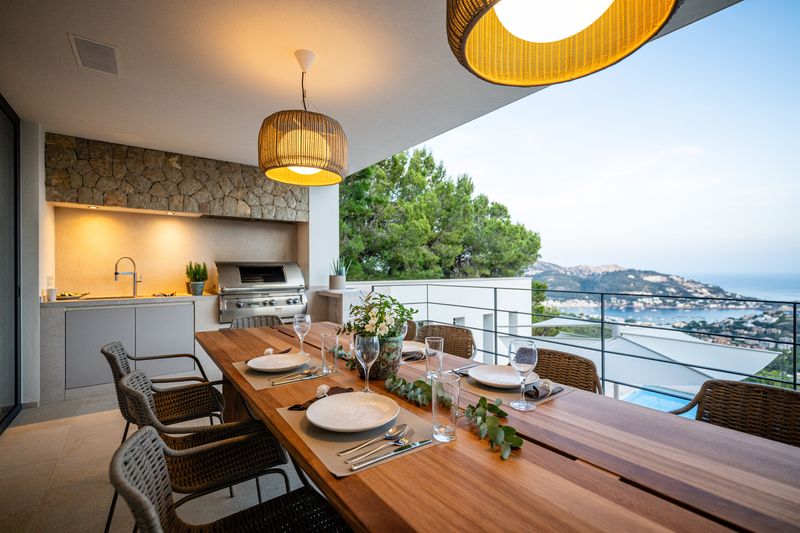 Outdoor dining terrace with pendant lights and a sea view