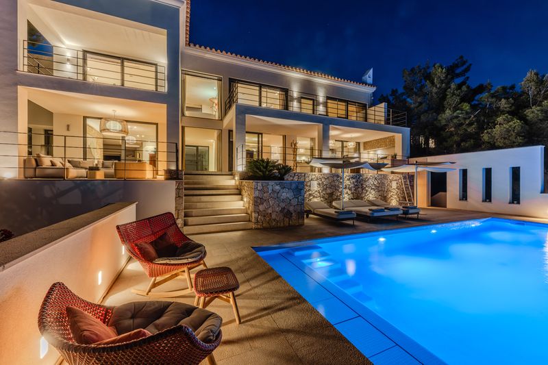 The villa and the illuminated infinity pool at dusk